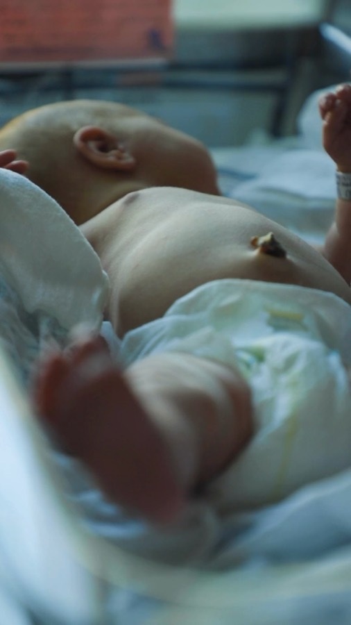 A newborn asleep, wrapped in a blanket